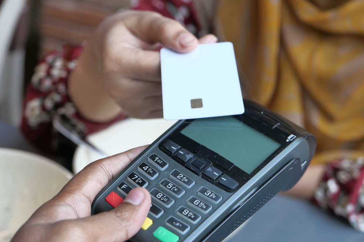 donna che passa il bancomat sul pos