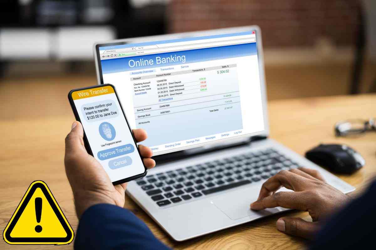 Persona che effettua bonifico tramite app di home banking e segnale di pericolo