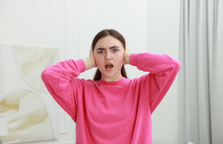 donna che si tappa le orecchie con le mani