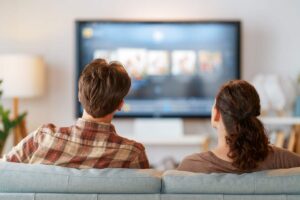 persone che guardano la tv sul divano