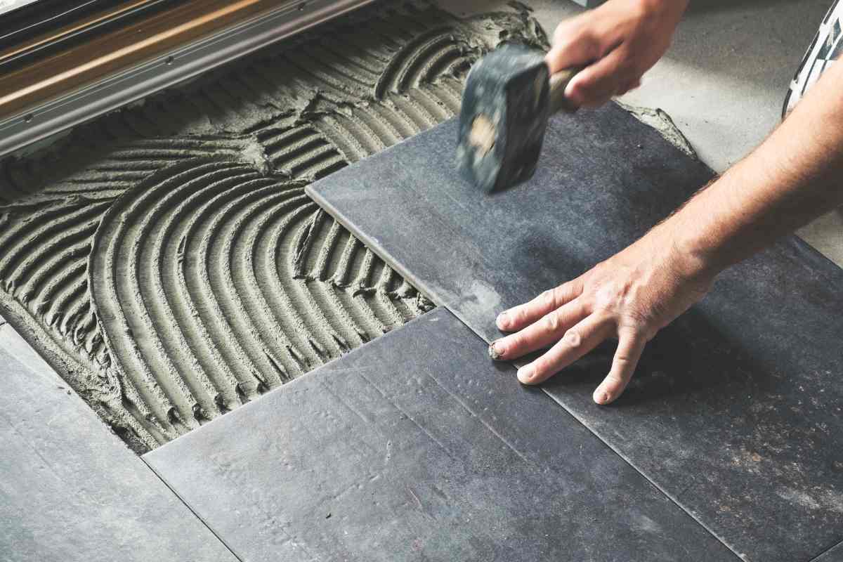 tecnico che installa piastrelle nere