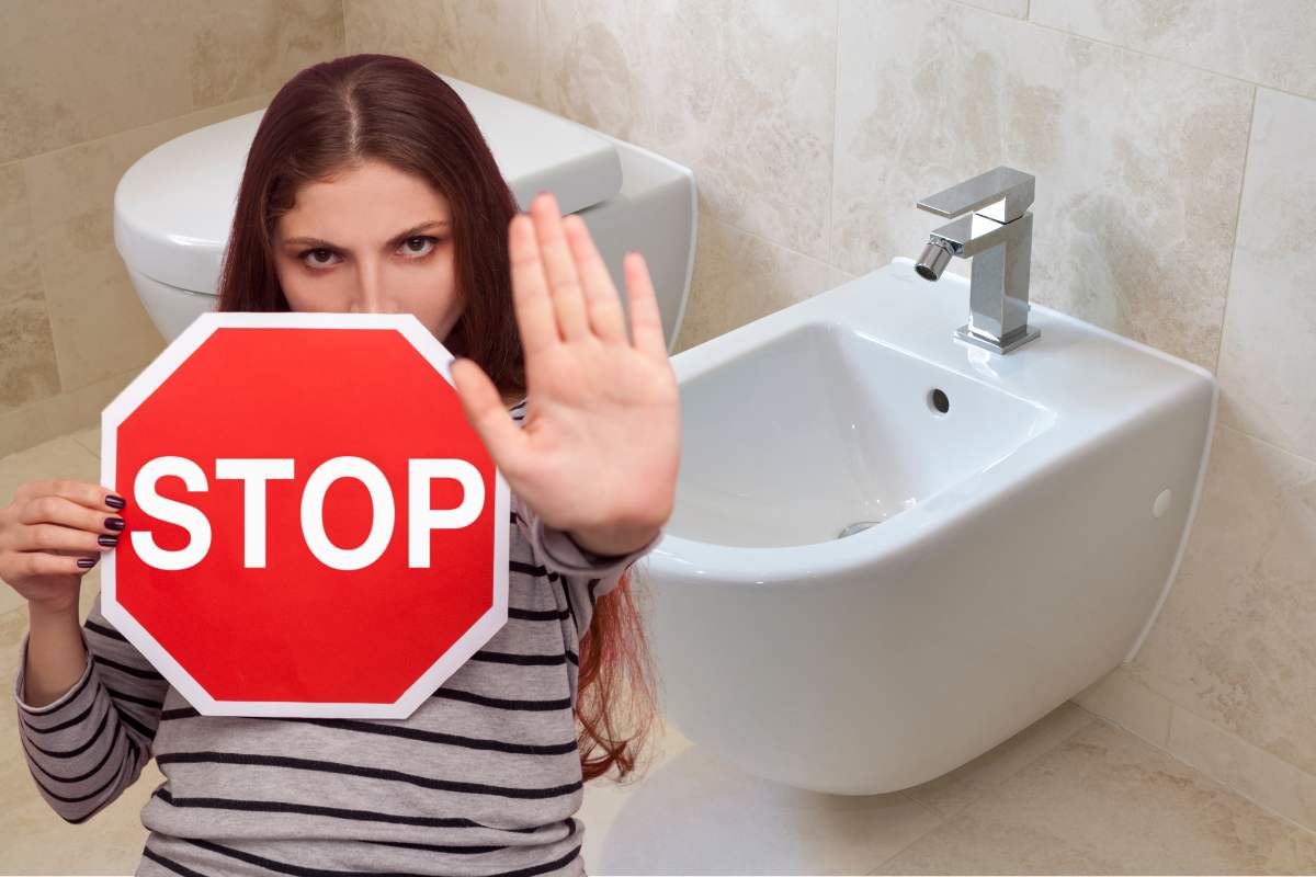 bidet sullo sfondo e donna con segnale di stop