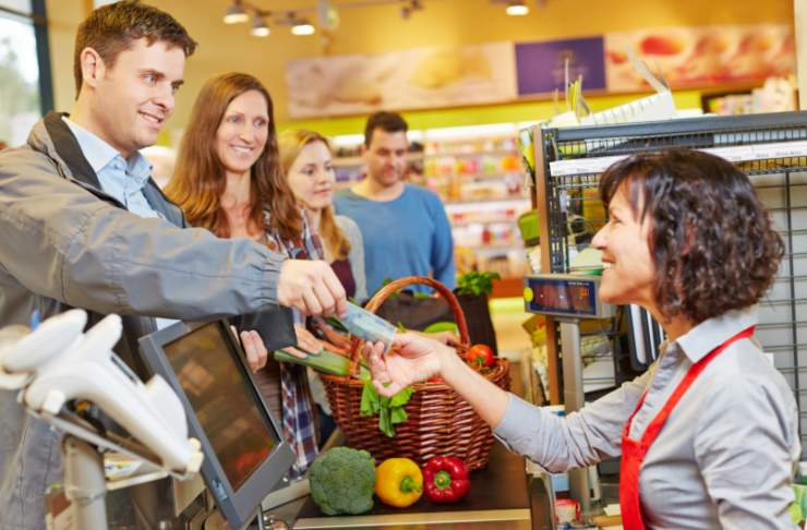 persone sorridenti alla cassa del supermercato